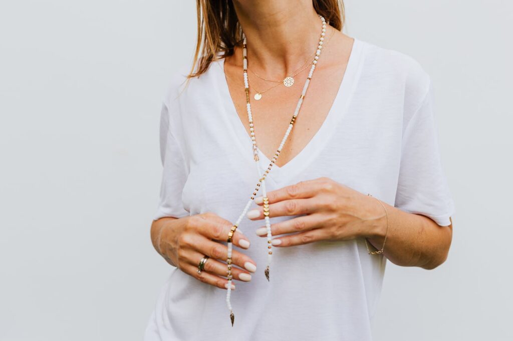 Woman in White Top Wearing Beads Necklace