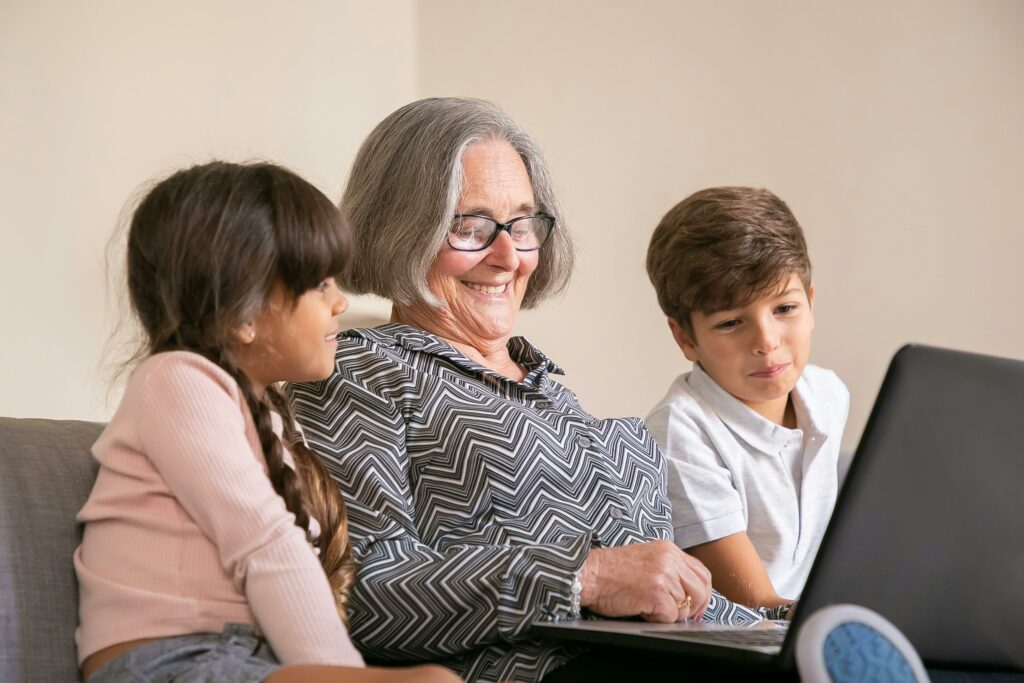 Elderly Woman Sitting on Sofa Using Laptop